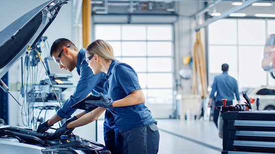 ASE certified mechanic working under the hood of a car